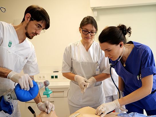 Medizinstudenten üben Wiederbelebung an einem Übungspuppe in einem Schulungsraum.