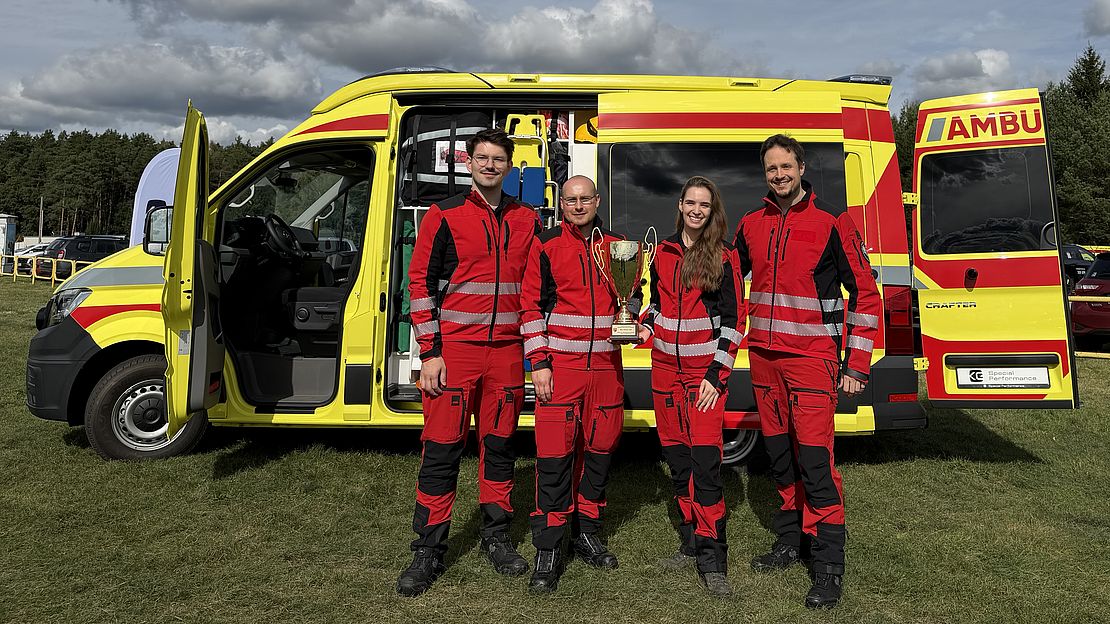 Rotes Kreuz Team mit Pokal vor Rettungswagen in Österreich