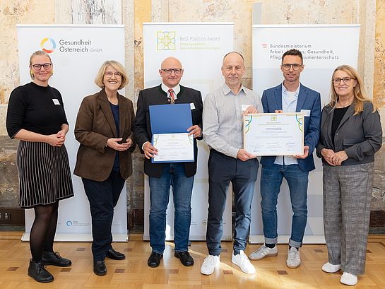 Best Practice Award: Sechs Personen mit Urkunden und Auszeichnungen in Wien